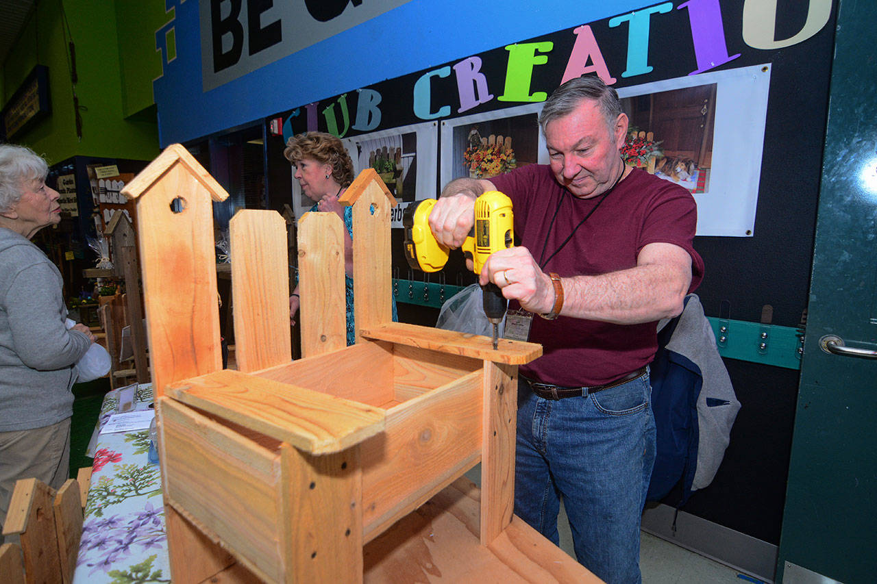 Larry Stacey of Walma’s Creations builds a bench planter box during the 19th annual Soroptimist Gala Garden Show in Sequim on Sunday. (Jesse Major/Peninsula Daily News)