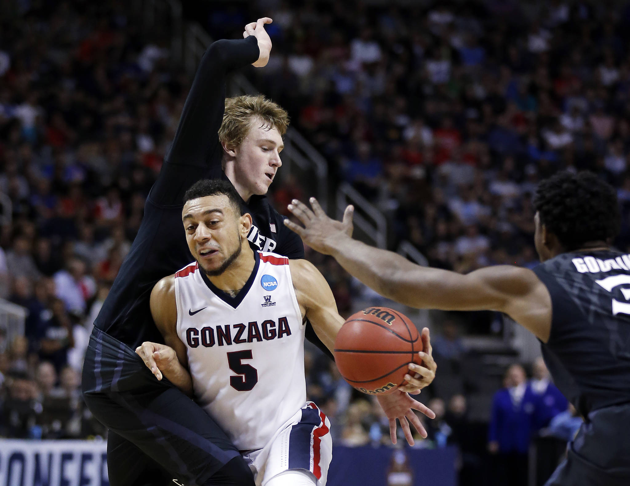 Gonzaga guard Nigel Williams-Goss (5) dribbles between Xavier guard J.P. Macura, left, and Quentin Goodin during the first half of an NCAA Tournament college basketball regional final game Saturday, March 25, 2017, in San Jose, Calif. (AP Photo/Tony Avelar)