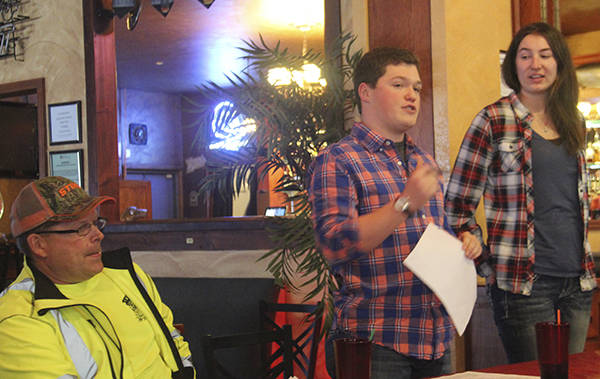 Zachary Carlson and Jessica Paul explain to Forks Chamber of Commerce members their plan for a successful auction as Quillayute Valley Scholarship Auction chairman Jerry Leppell looks on earlier this month. (Christi Baron/Olympic Peninsula News Group)