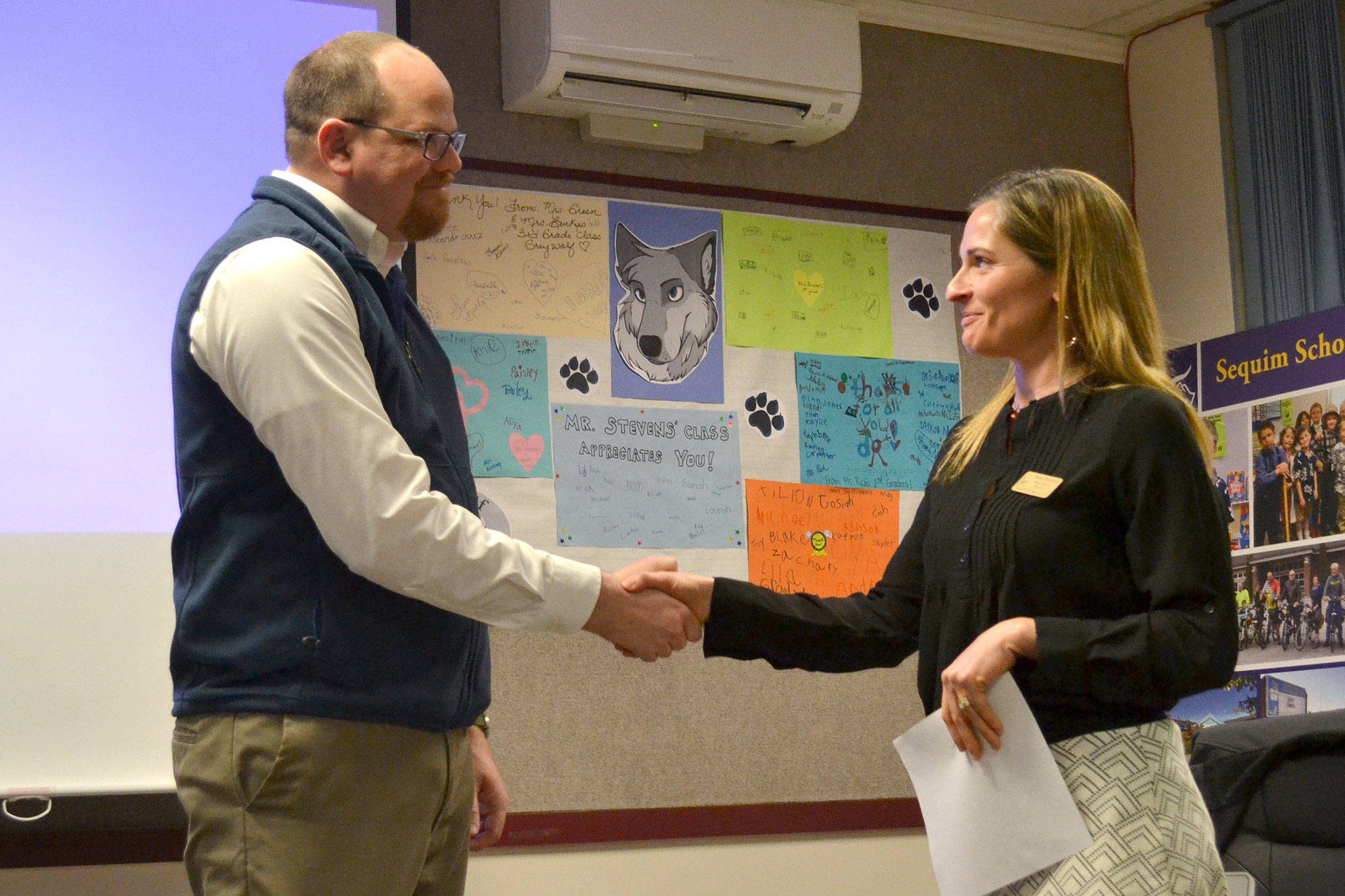 Brian Kuh shakes hands with Robin Henrikson, board president for the Sequim School Board, on Monday after he was sworn in as a new board director. He replaces Bev Horan, who stepped down March 7. (Matthew Nash/Olympic Peninsula News Group)