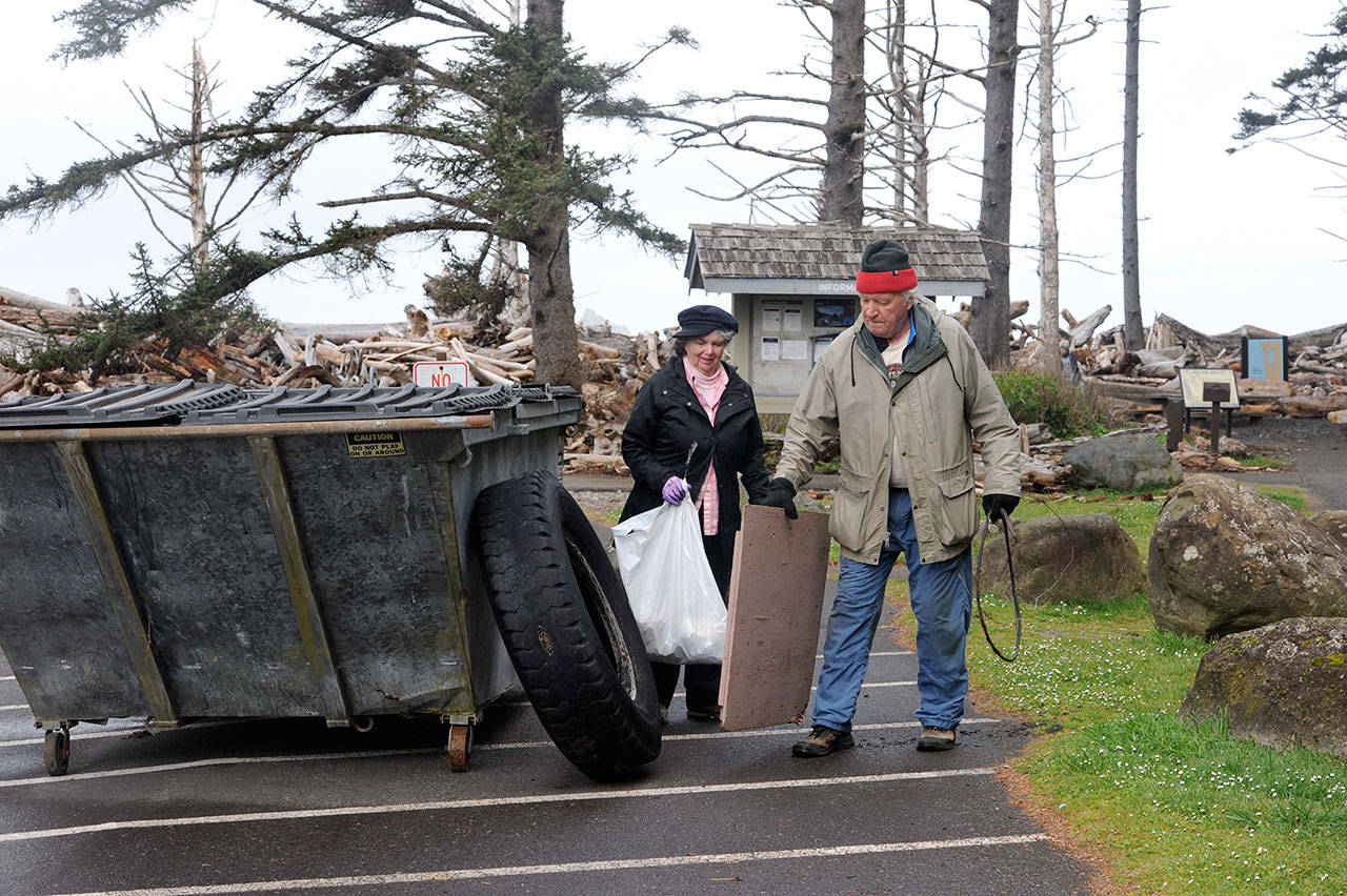 Beverly Rosenow and Francis Brophy of Port Townsend with the Mountaineers deposit trash at the Rialto Beach parking lot during a beach cleanup. (Lonnie Archbald/for Peninsula Daily News)