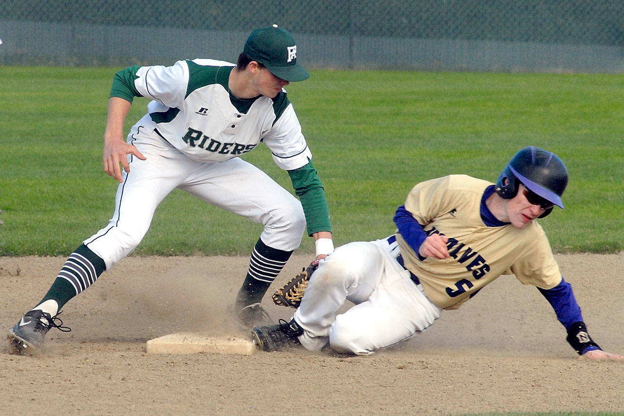 Keith Thorpe/Peninsula Daily News Port Angeles’ Colton McGuffey, left, cuts off a second base steal attempt by Sequim’s Justin Porter in the third inning on Wednesday at Volunteer Field in Port Angeles.