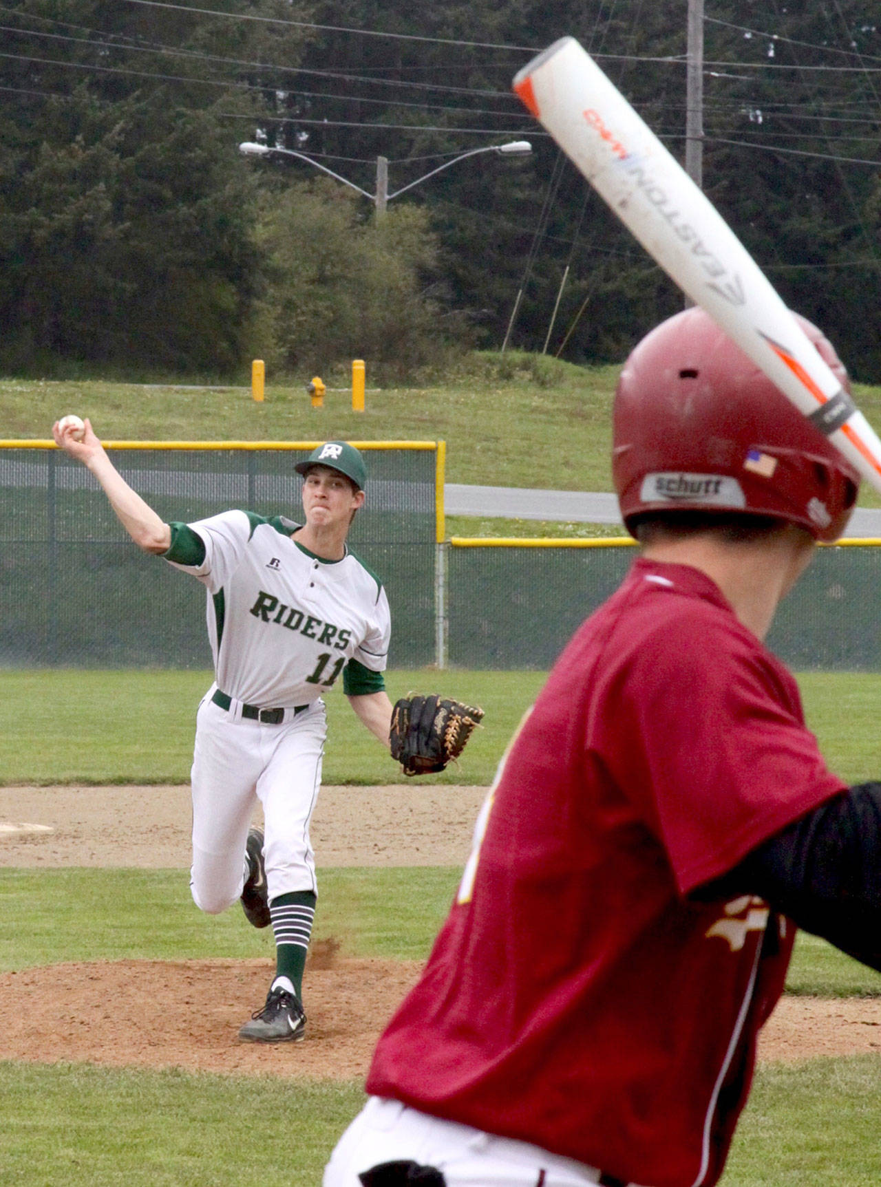 Dave Logan/for Peninsula Daily News                                Colton McGuffey for Port Angeles pitches to a Kingston batter at the start of the Roughriders game Saturday at Volunteer Park. McGuffey and Kyle Blankenship combined for a three-hitter.