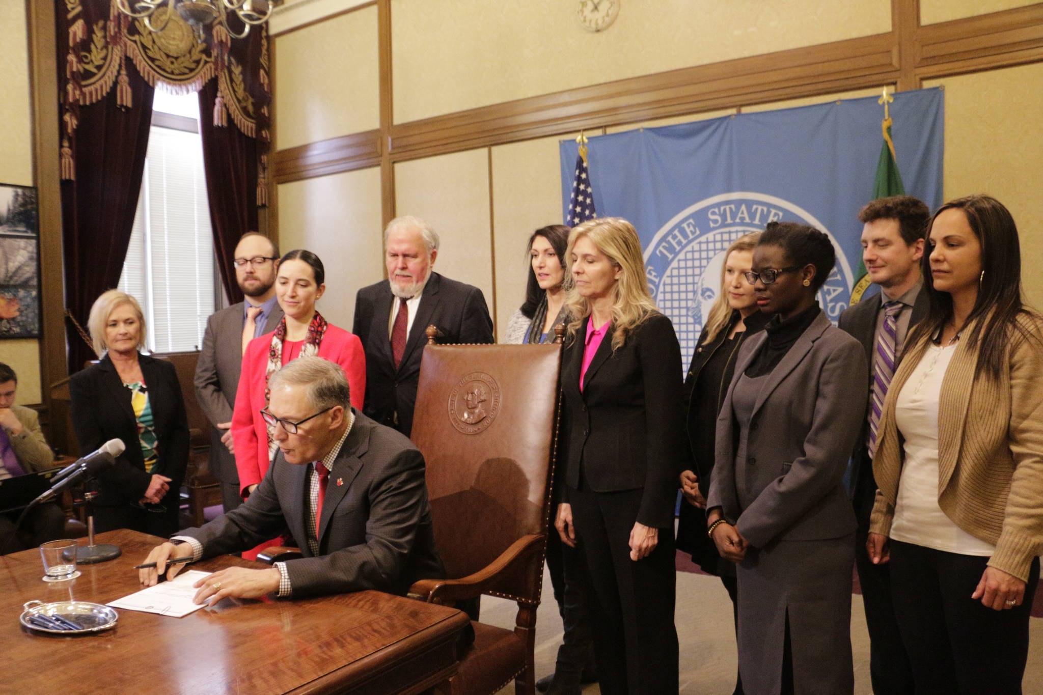 Gov. Jay Inslee signs a measure Tuesday in Olympia to make it easier for victims of sex trafficking to vacate prostitution convictions. Current law doesn’t allow victims to vacate prostitution convictions if other crimes exist on their criminal record. (Rachel La Corte/The Associated Press)
