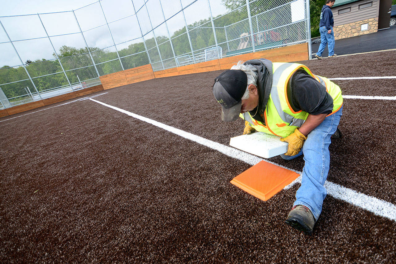 Lower Elwha Klallam facilities maintenance worker Mitch Boyd sets third base at the tribe’s new athletic facility, the Billy Whiteshoes Memorial Park. The park is expected to be finished within the next two weeks. (Jesse Major/Peninsula Daily News)