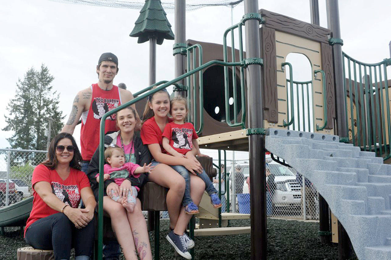 Perched on playground equipment at the Tod Horton On Deck Playground are, from left, seated, De Ann Horton; her daughter Hailey Daniels holding her youngest daughter, Mallie; and Kray Horton, holding Kinzie Daniels. Dustin Daniels, Hailey’s husband, is standing in back. Not pictured is De Ann’s oldest daughter, Whitney. (Lonnie Archibald/for Peninsula Daily News)