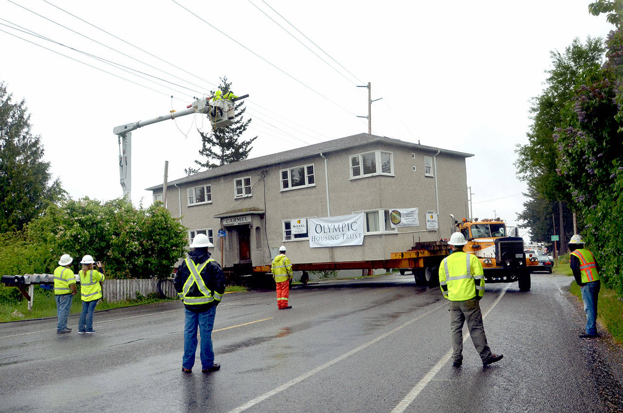 An unaccounted-for fiber-optic line on the corner of Landes and 19th streets slows the moving of a two-story apartment complex in Port Townsend on Thursday. (Cydney McFarland/Peninsula Daily News)