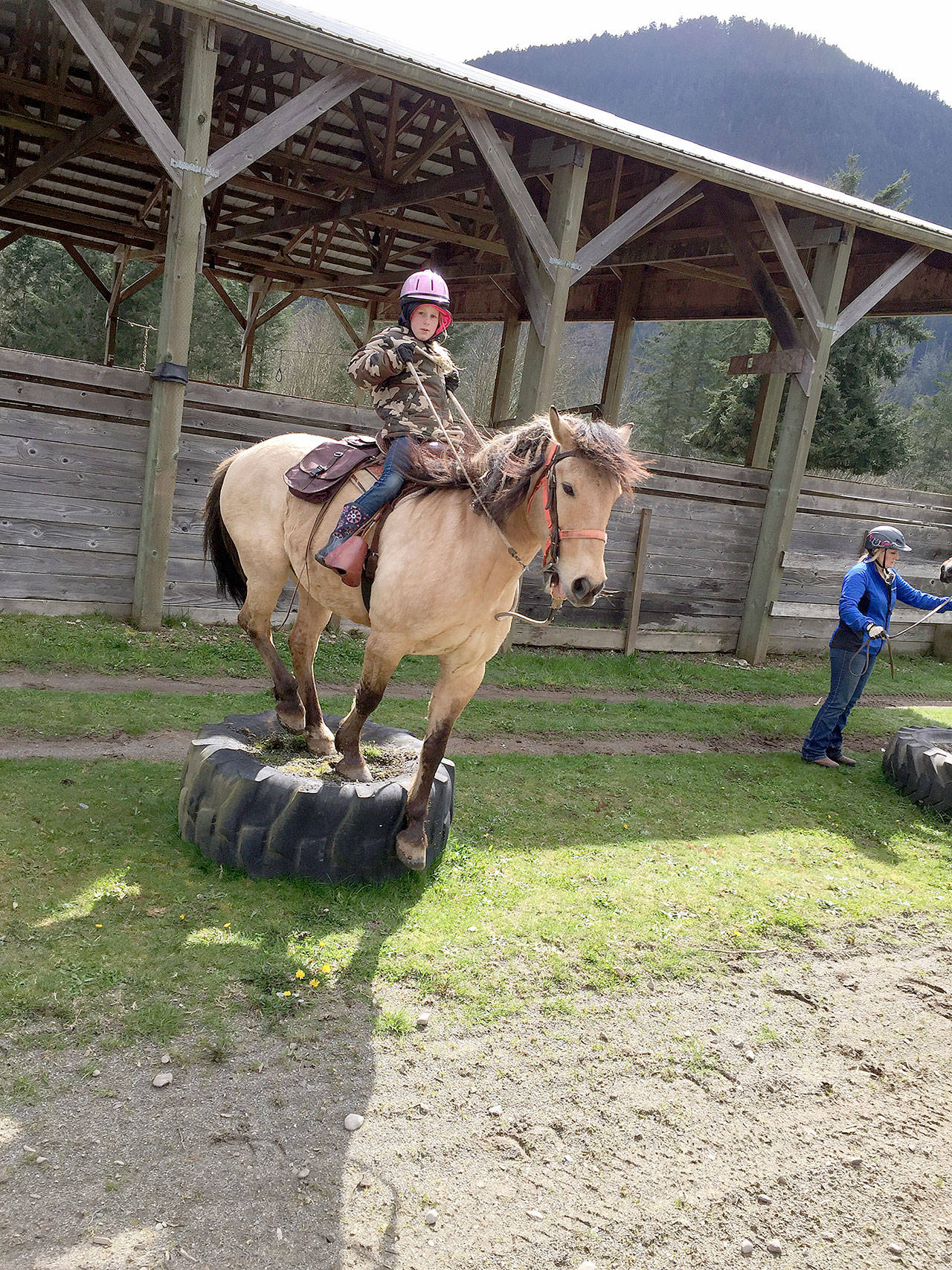 When the Mount Olympus Chapter of Back Country Horsemen held a spring tuneup day at Spirit Horse Ranch last month Rylie Baysinger, 8, learned how to guide her horse, Scout, to step all four legs onto the tractor tire, stand still and then turn to the right before stepping down. (Sherry Baysinger)