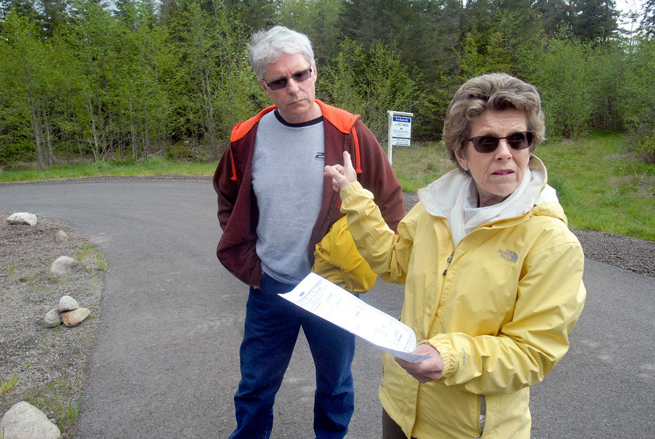 Ron and Barbara Carr, residents of the O’Brien Meadows development in the Little Oklahoma area near the foothills southeast of Port Angeles, point out property near their home that might not be governed by land-use rules that the rest of their neighborhood must adhere to. (Keith Thorpe/Peninsula Daily News)