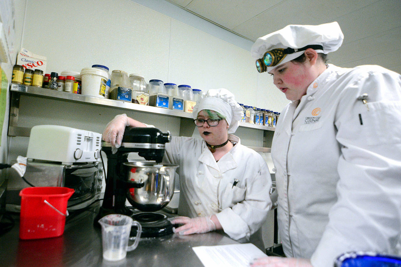 Senior Jasmine White and junior Cassy Reese prepare to bake bagels during their culinary class at the North Olympic Peninsula Skills Center on Tuesday. (Jesse Major/Peninsula Daily News)
