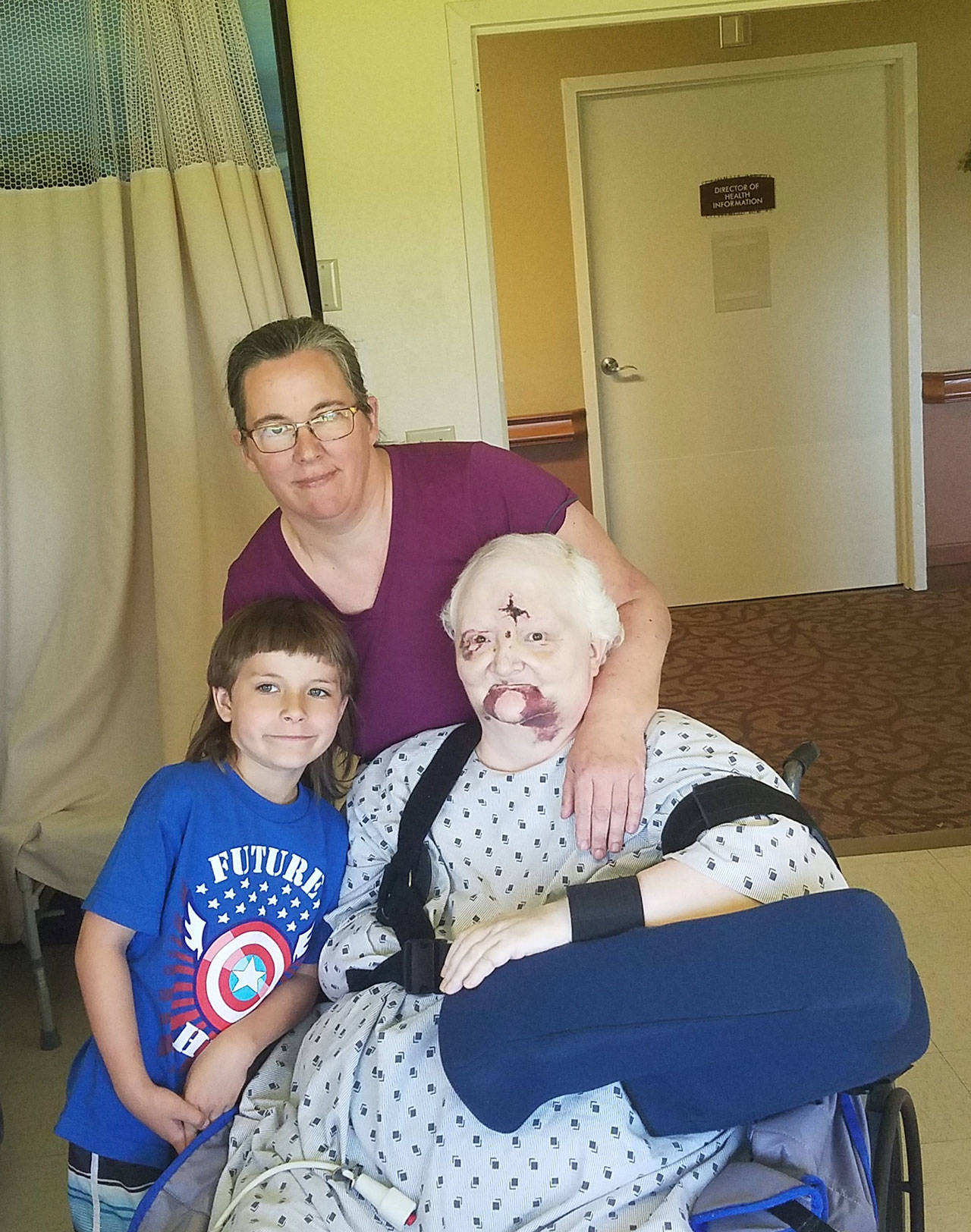 From left, Mikhail Groth-Swartwood, Crystal Groth and Shawn Swartwood at a Port Townsend-area rehabilitation center Friday as Swartwood recovers from a May 18 fall from a Rhododendron Festival Ferris wheel. (Ashton Dennis)