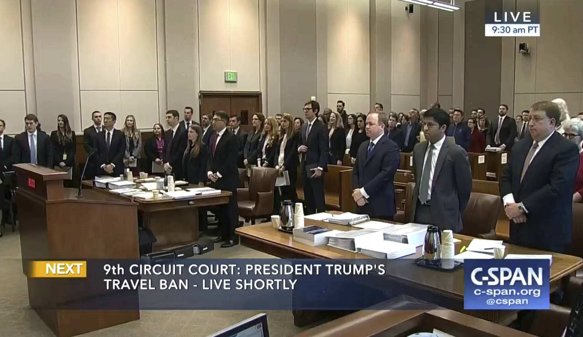 In this image made from a C-SPAN video, participants and members in the gallery stand as three judges for the 9th US Circuit Court of Appeals enter the room in Seattle on Monday. (CSPAN via AP, Pool)