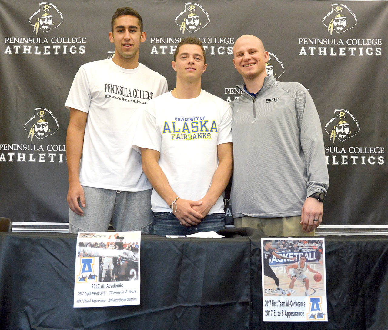 Peninsula College Athletics                                Peninsula College men’s basketball players, from left, Alex Baham and Jalon McCullough are pictured with Pirates head coach Mitch Freeman after signing letters of intent to continue their college careers with the University of Alaska-Fairbanks. Baham is from Wasilla, Alaska and McCullough is from Fairbanks.