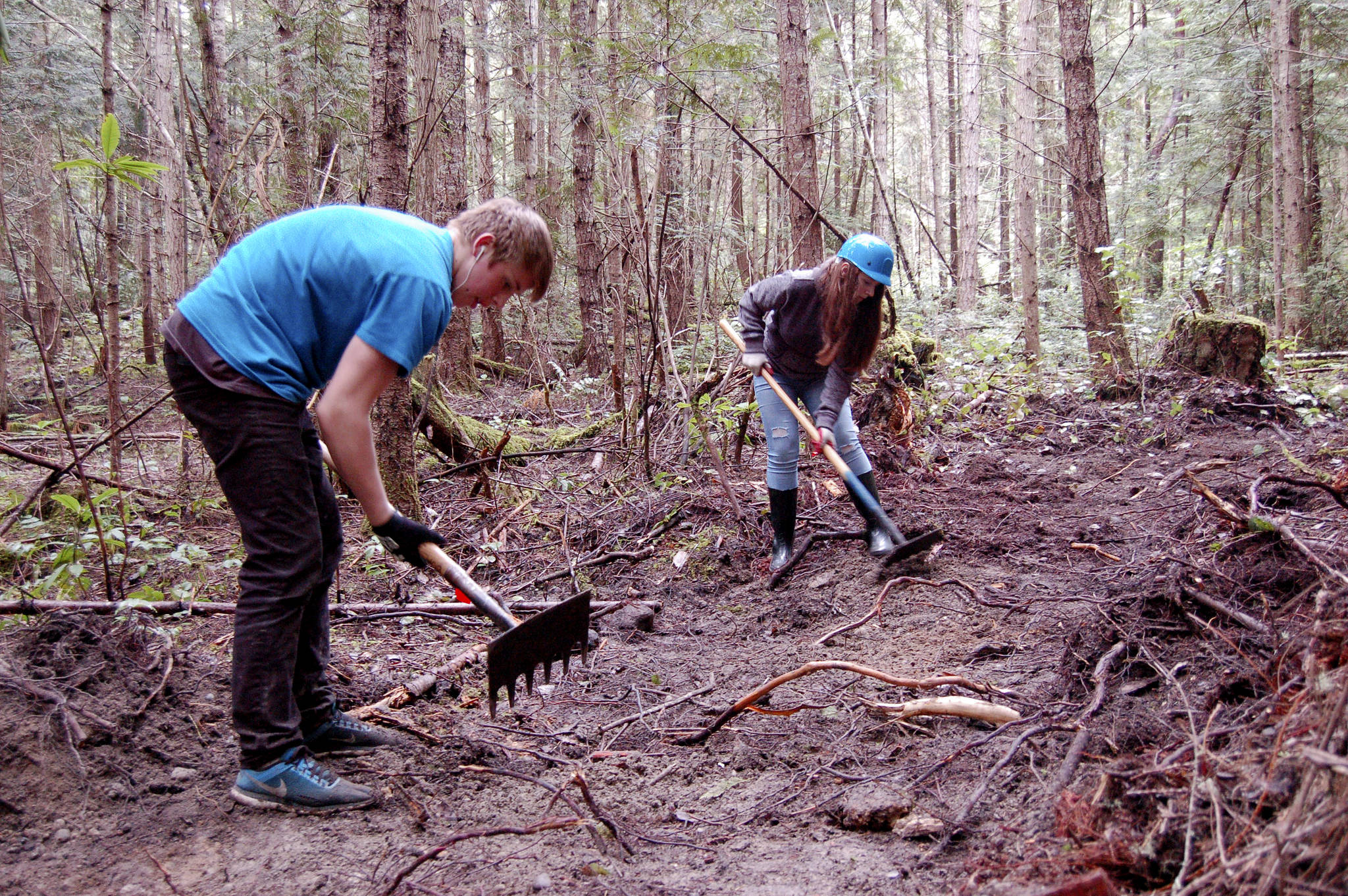 Sequim High School students Sequoia Swindler, left, and Sara Minty clear a trail last Wednesday on the Miller Peninsula as part of a project led by Powell Jones, executive director of the Dungeness River Audubon Center, to bring local youths into the wilderness. The trail was funded by a grant through the U.S. Forest Service. (Matthew Nash/Olympic Peninsula News Group)