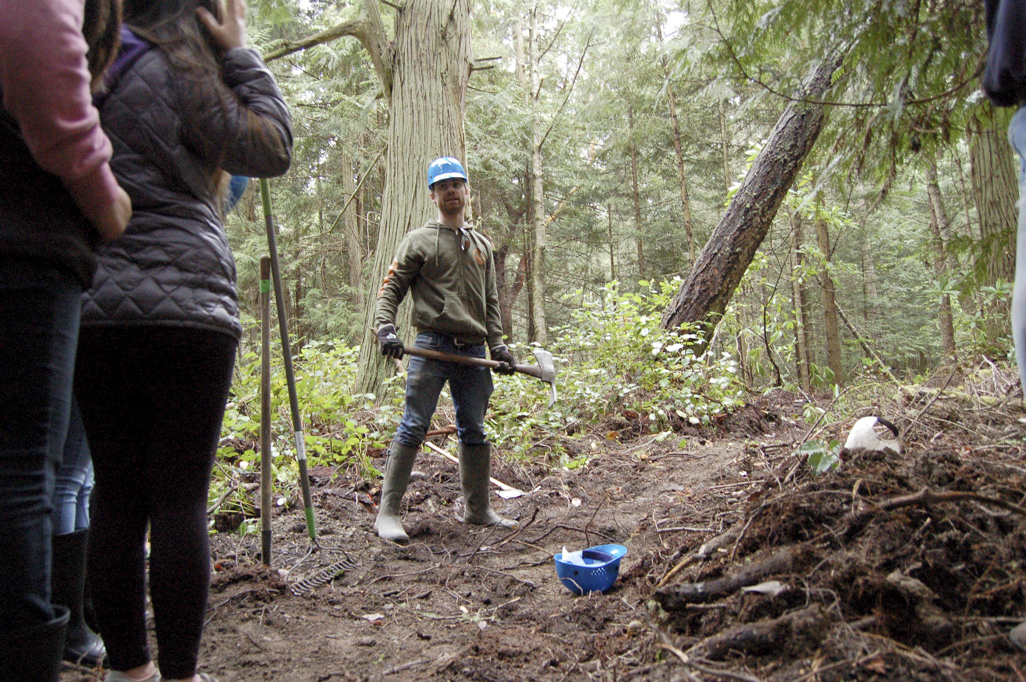 Powell Jones, executive director of the Dungeness River Audubon Center, shows students how to use tools like a McLeod for clearing trails. Each student got to try different tools as they worked to clear a trail over a few hours last week. (Matthew Nash/Olympic Peninsula News Group)