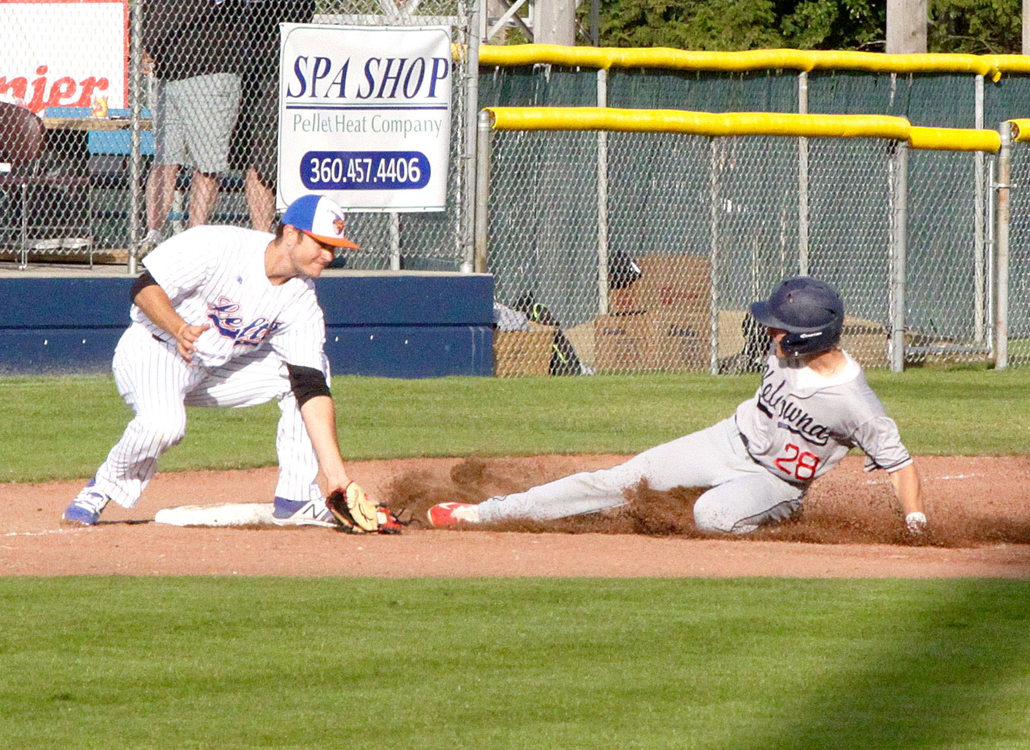 Dave Logan/for Peninsula Daily News Davis Todischuk of Kelowna slides safely into third under the tag of Lefties third baseman Jake Portaro in the second inning of Kelowna’s back-and-forth 8-7 win Monday evening.