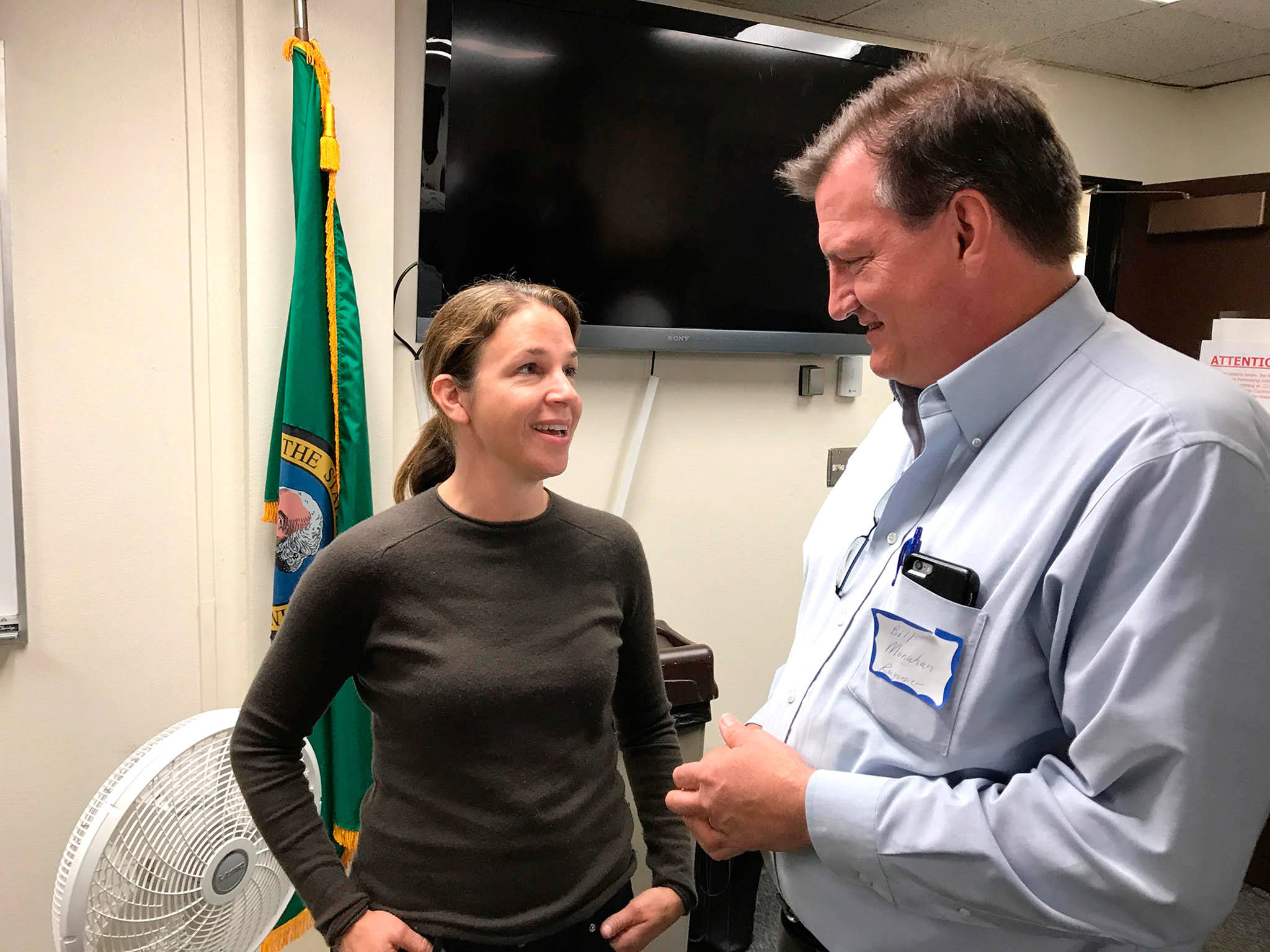 Hilary Franz, state commissioner of public lands, talks with Bill Monahan, a Rayonier forest products company supervisor, before Franz’s presentation on a new agency initiative Thursday to a packed audience at the Clallam County Courthouse. (Paul Gottlieb/Peninsula Daily News)