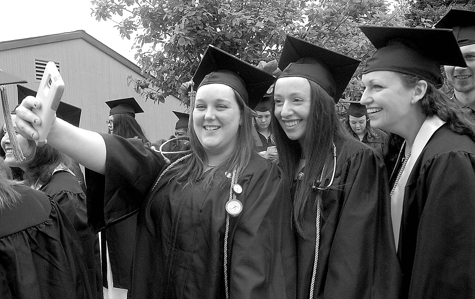 Nursing students, from left, Carrie Bertman of Port Angeles, Michelle Abell-Sietz of Sequim and Jessica Meek of Port Angeles pose for a group selfie while lining up for commencement ceremonies on Saturday on the Port Angeles campus of Peninsula College. A total of 275 students were set to take part in the proceedings out of 486 students receiving 600 degrees and certificates.