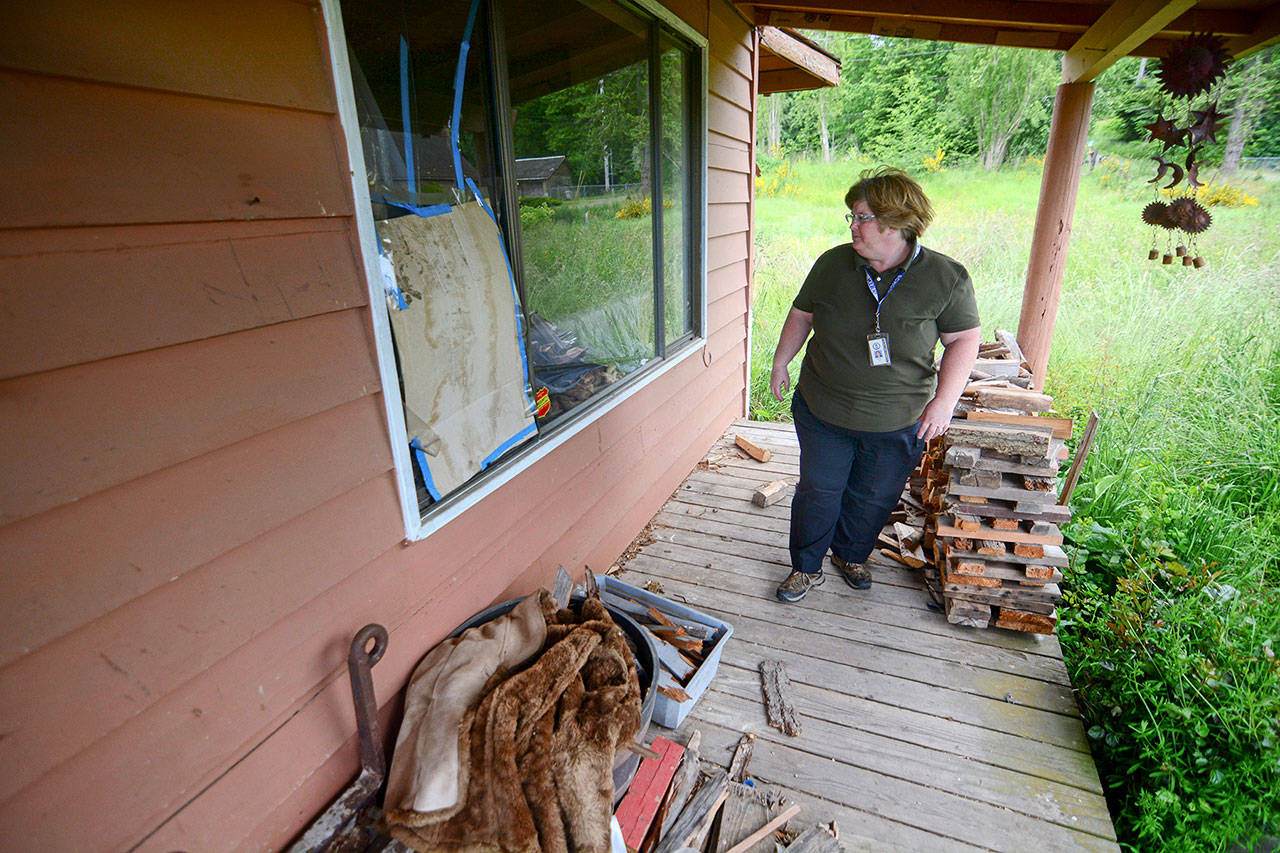 Barb McFall, Clallam County’s only code enforcement officer, looks over a vacant home. (Jesse Major/Peninsula Daily News)