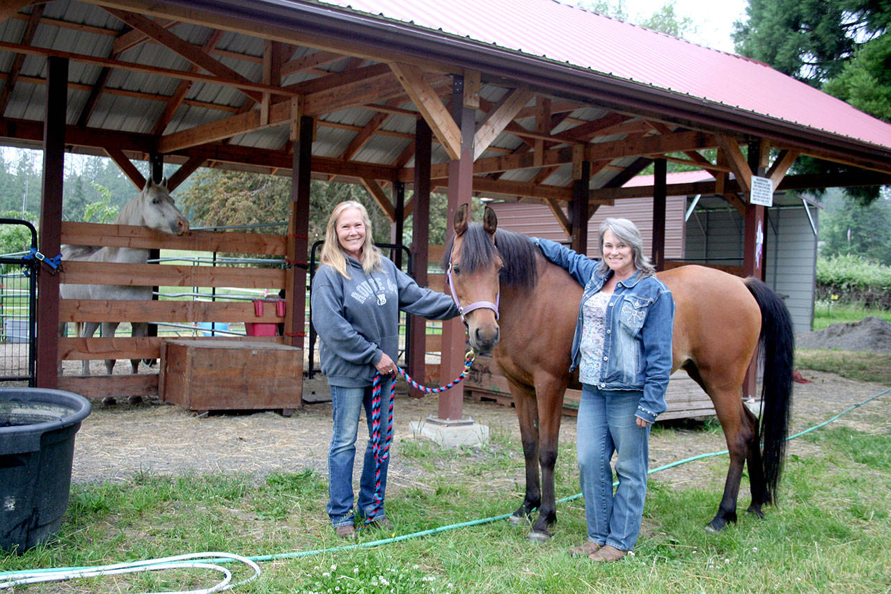 Olympic Peninsula Equine Network horse rescuers Valarie Jackson, left, and Diane Royall, with rescue horse Chloe, said within two weeks time eight starving and neglected horses came to live in their already full facility. (Karen Griffiths/for Peninsula Daily News)