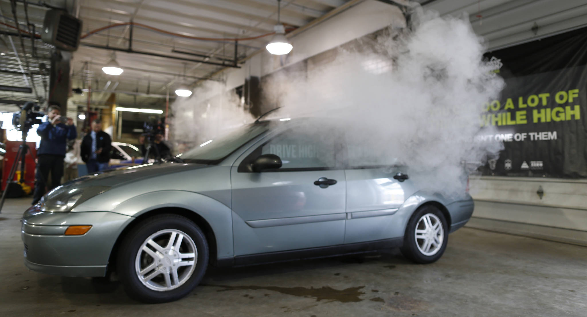 In this April 16, 2015, photo, smoke created by water vapor billows out of the windows of a car during a demonstration by the Colorado Department of Transportation in southeast Denver. (David Zalubowski/The Associated Press)