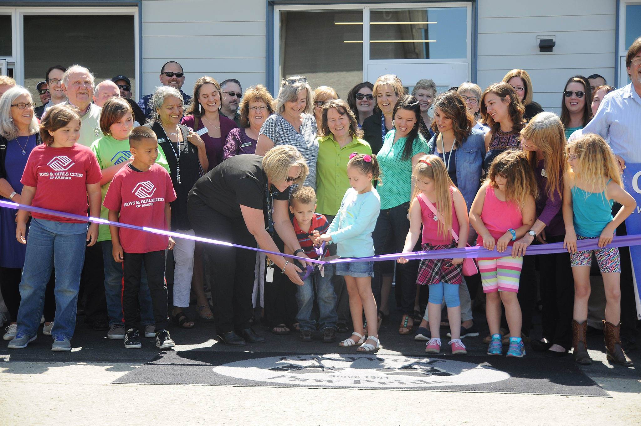 Greywolf Elementary School Principal Donna Hudson helps Bianca Lopez and Benjamin Smith with the ribbon-cutting at Greywolf Elementary School’s new kindergarten classroom building, constructed using cross-laminated timber, on Wednesday. (Michael Dashiell/Olympic Peninsula News Group)