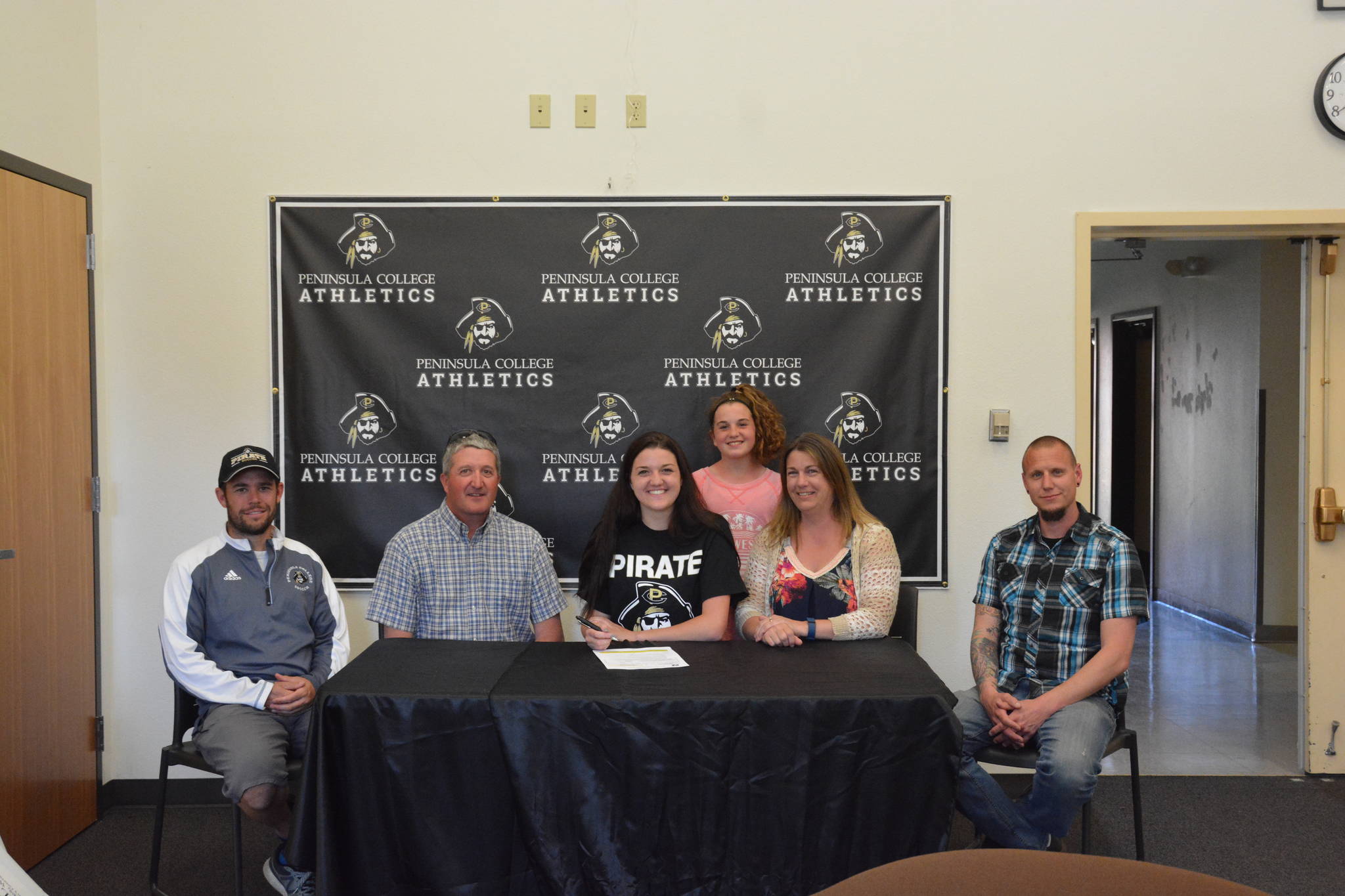 Peninsula College Athletics                                Sequim’s Erin Vig (center) in May signs a letter of intent to play at Peninsula College this fall. Joining her are, from left, PC head coach Kanyon Anderson, dad Craig, sister Lainey, mom Julie and Sequim High head coach Derek Vandervelde.