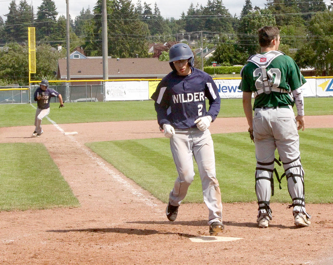Dave Logan/for Peninsula Daily News Wilder Senior’s Gavin Guerrero scores while teammate Matt Hendry rounds third base during a game against Lakeside Recovery earlier this summer.