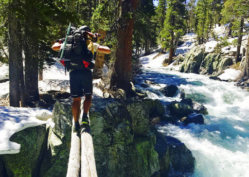 In this June 16 photo, Jake Gustafson crosses Bear Creek along the Pacific Crest Trail near Kings Canyon National Park, Calif. (Wesley Tils via AP)