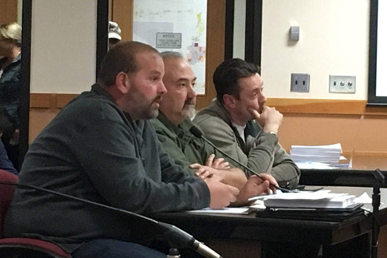 Chris Anderson, left, owner of CA Homes, testifies at a hearing with his staff for his proposed 73-unit manufactured home project in Carlsborg on June 1 in the Clallam County Courthouse. Anderson said he would comply with the additional studies Hearing Examiner Andrew Reeves gave him including a critical areas report and lighting plan.