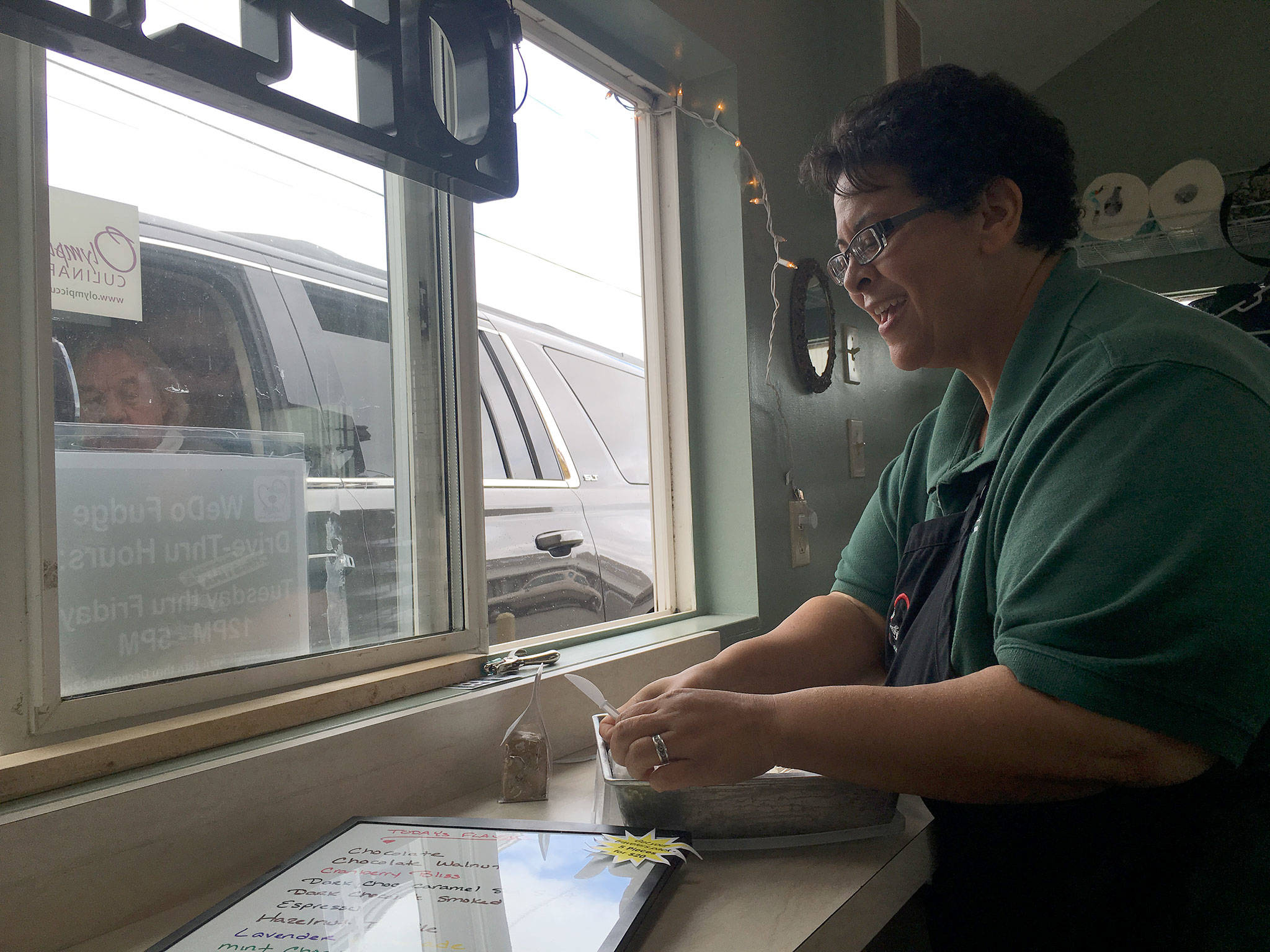 Christina Norman, co-owner of WeDo Fudge in Carlsborg, provides a fudge sample for a customer. She’s also offering prayer now if people ask. (Matthew Nash/Olympic Peninsula News Group)
