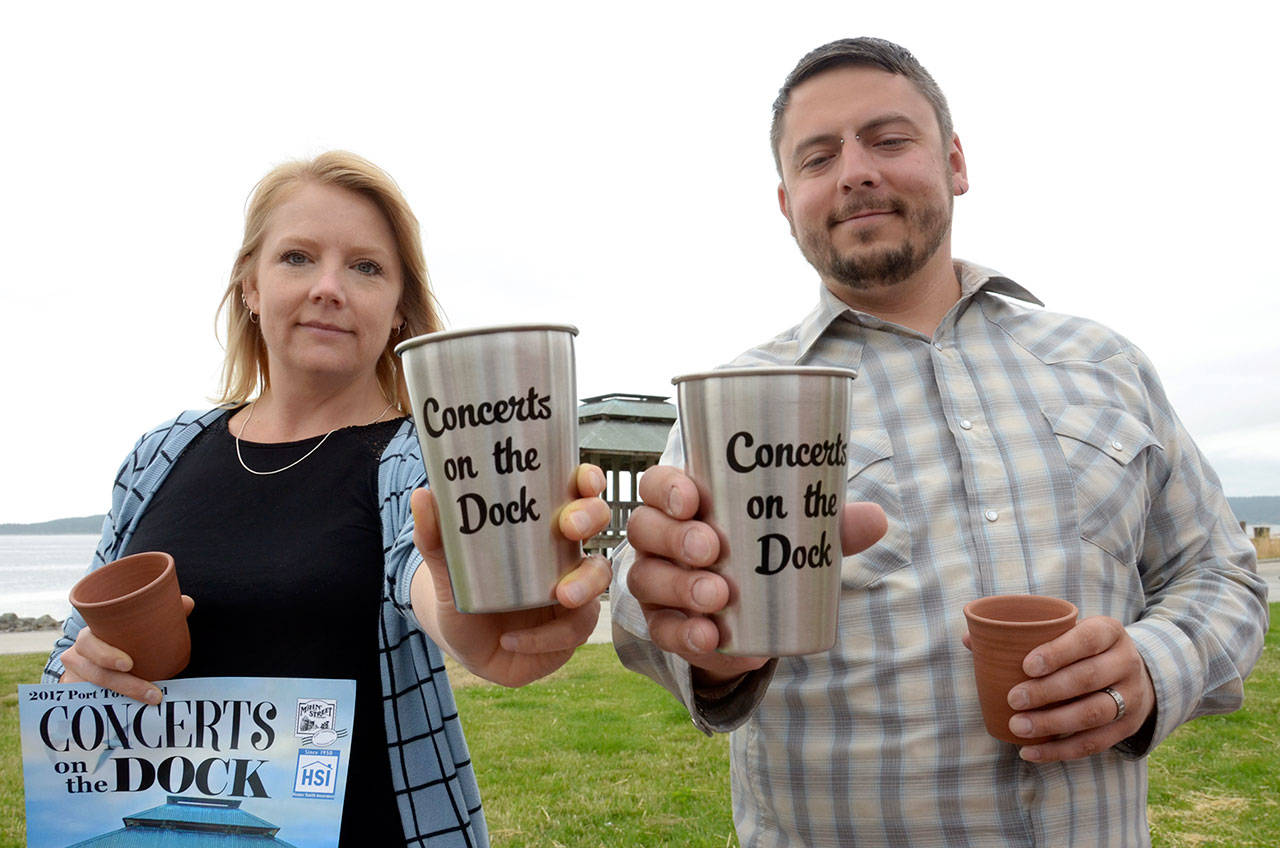 Port Townsend Main Street program coordinator Dawn Pierson and music coordinator Dominic Svornich show off Concerts on the Dock reusable cups, which will be used at this year’s summer concert series in an effort to go green. (Cydney McFarland/Peninsula Daily News)