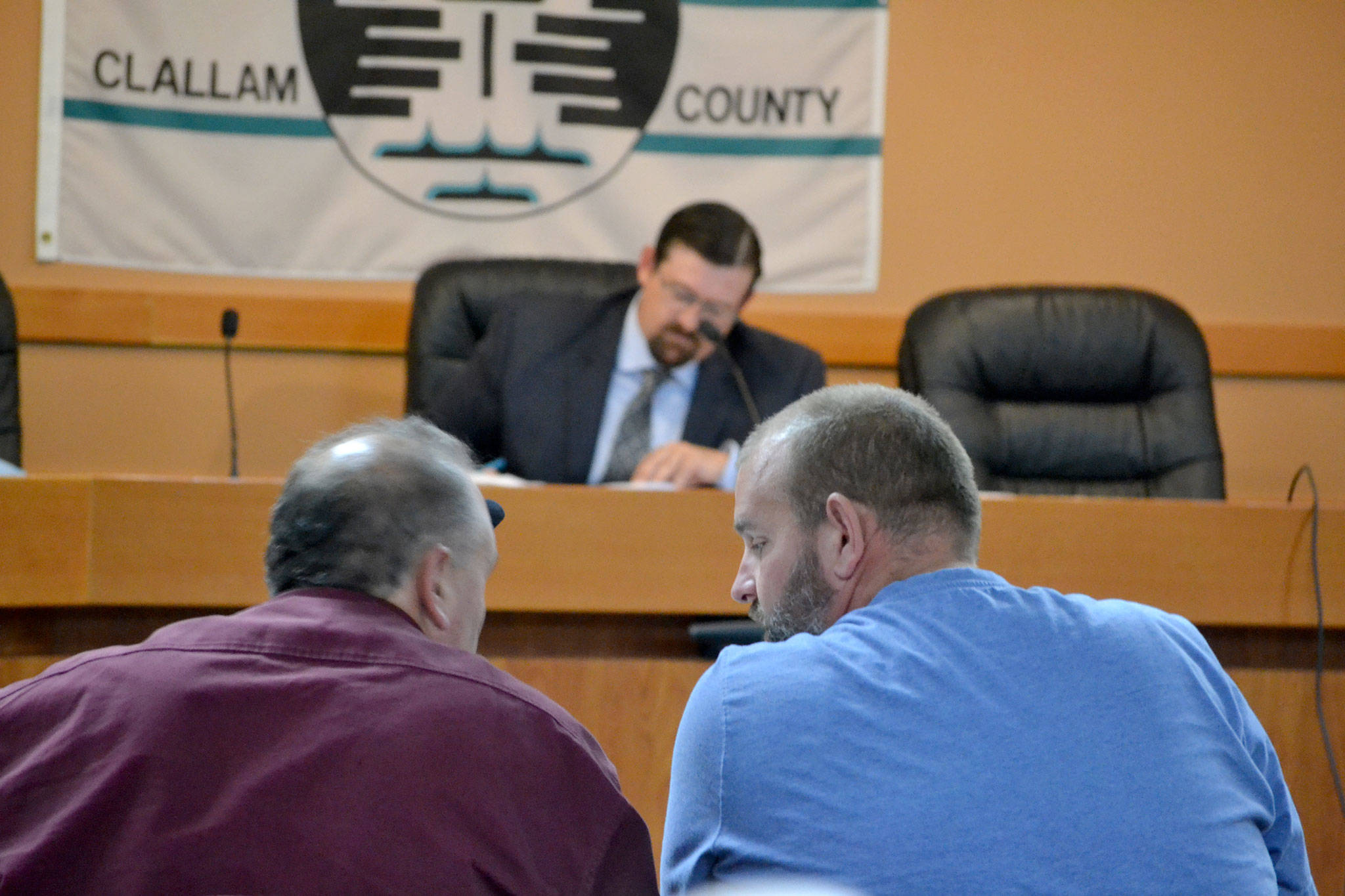 Tracy Gudgel of Zenovic & Associates Inc., left, and Chris Anderson of CA Homes Inc., right, confer during a hearing on a proposal to build 73 manufactured homes in Carlsborg. (Matthew Nash/Olympic Peninsula News Group)
