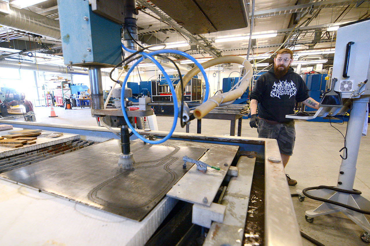 Jamie Trowbridge, the Composite Recycling Technology Center’s first production employee, cuts pickleball paddles Monday afternoon. (Jesse Major/Peninsula Daily News)