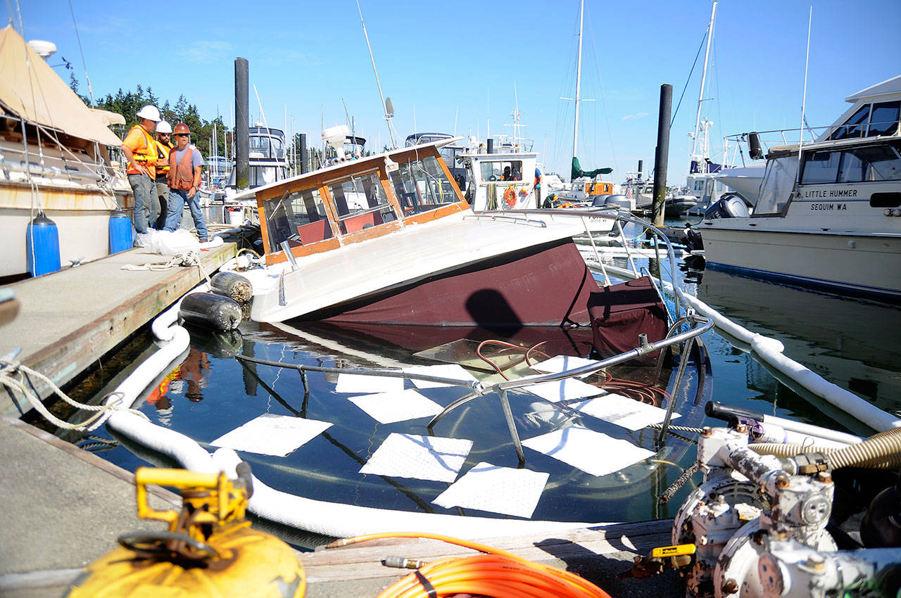 Personnel from Global Diving and Salvage work to secure leaking fuel from the Seattle-based Lady Mick, which began sinking Tuesday evening at John Wayne Marina. (Michael Dashiell/Olympic Peninsula News Group)