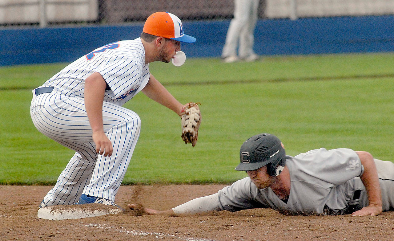 Lefties first baseman Michael Ciancio blows a bubble with his chewing gum while trying to catch Cowlitz’ Austin Ingraham off the bag during Port Angeles’ 6-1 win.                                Keith Thorpe/Peninsula Daily News
