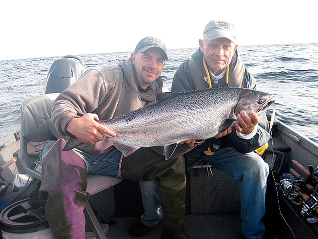 Eric Thomson, left, and Pete Rosko of Port Angeles, brought in this 23-pound chinook while using a 1-ounce all glow Kandlefish lure at Freshwater Bay. The pair have been fishing together for 17 years.