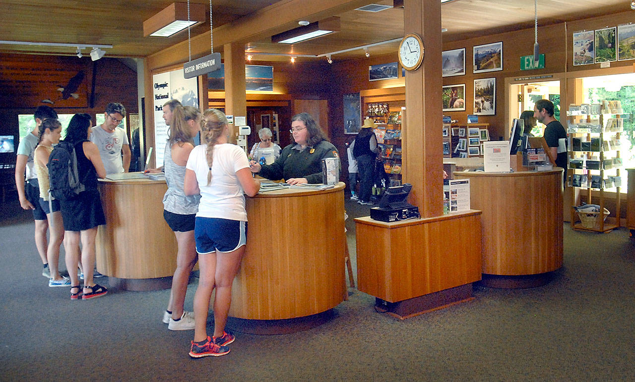 Visitors acquire information about Olympic National Park at the park’s Port Angeles visitor center Wednesday. (Keith Thorpe/Peninsula Daily News)