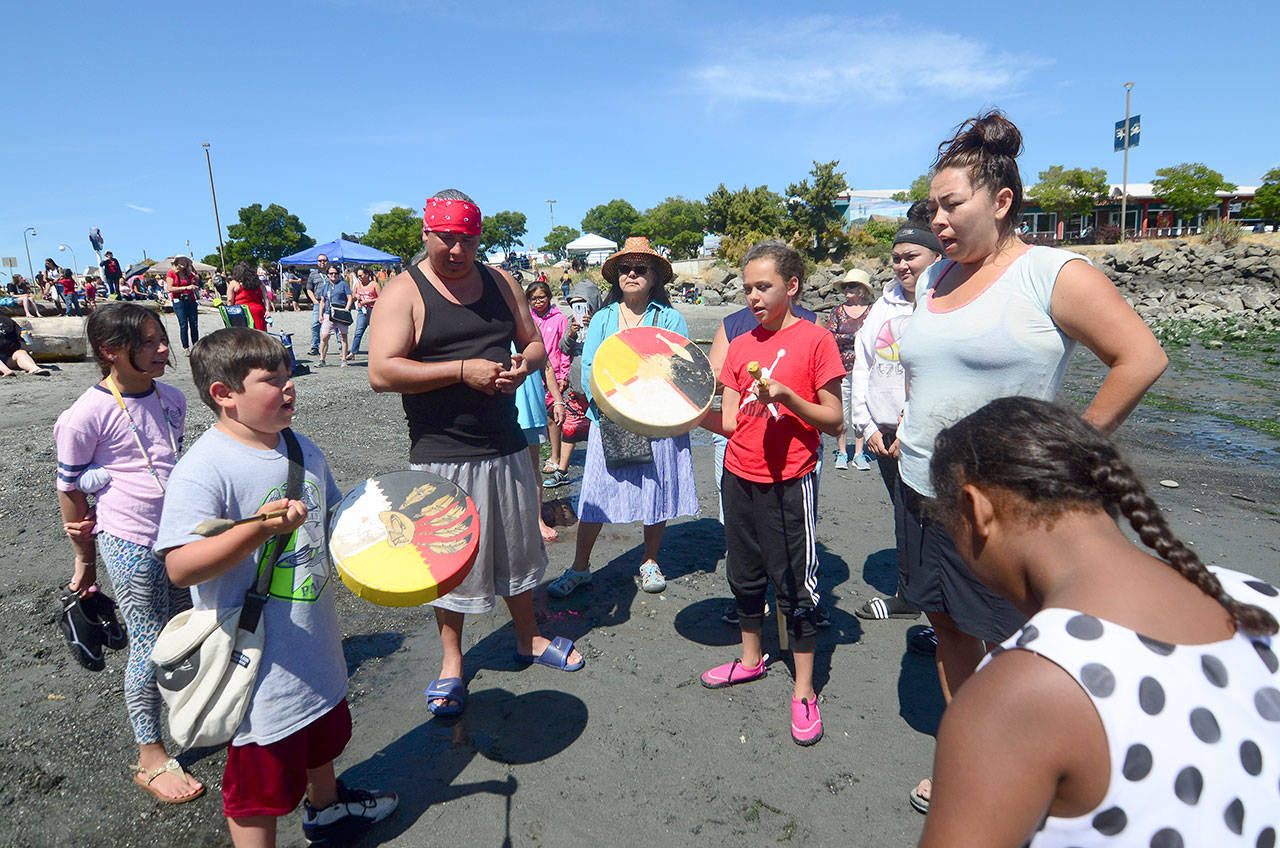 Tribal members sing on Hollywood Beach after canoes from the Nisqually Indian Tribe and Jamestown S’Klallam Tribe arrived in Port Angeles on Monday afternoon. (Jesse Major/Peninsula Daily News)