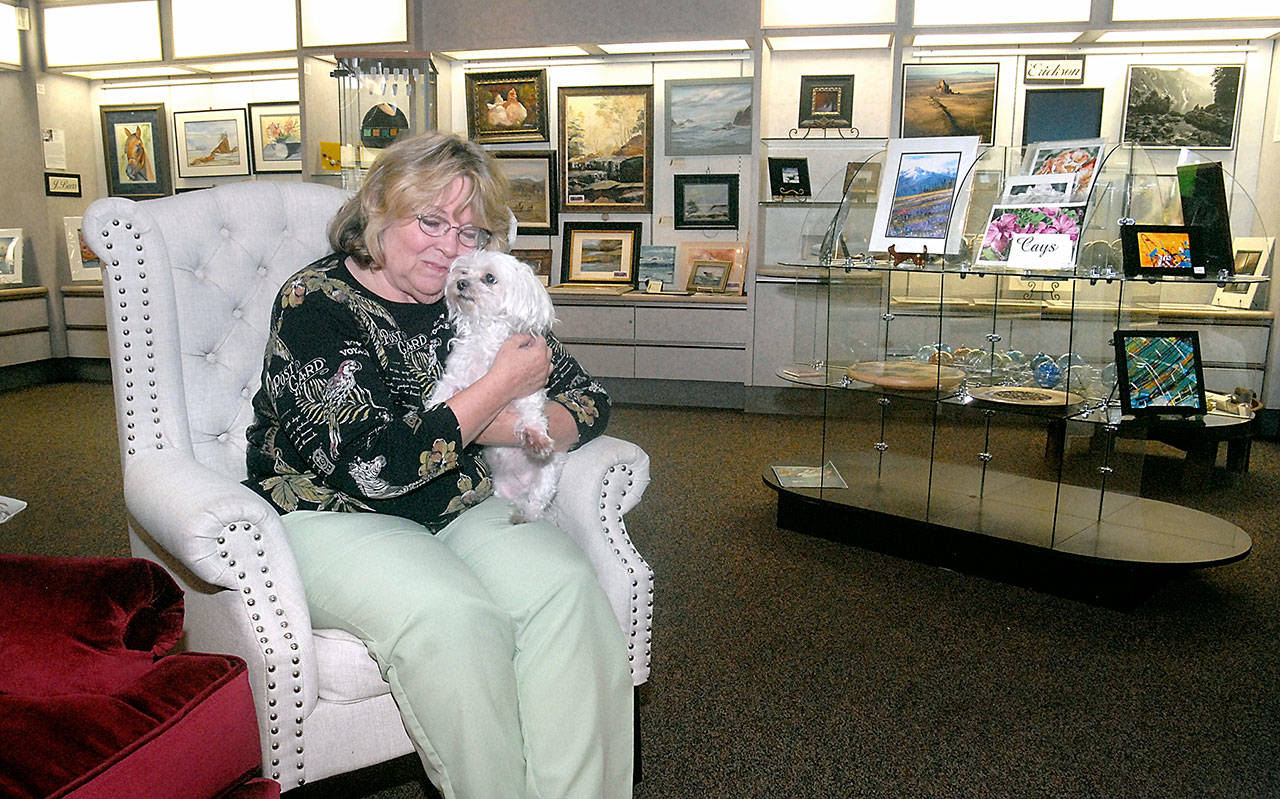 Sky Heatherton, along with her dog, Sasha, sits in her Heatherton Gallery at The Landing mall Friday on the Port Angeles waterfront. (Keith Thorpe/Peninsula Daily News)