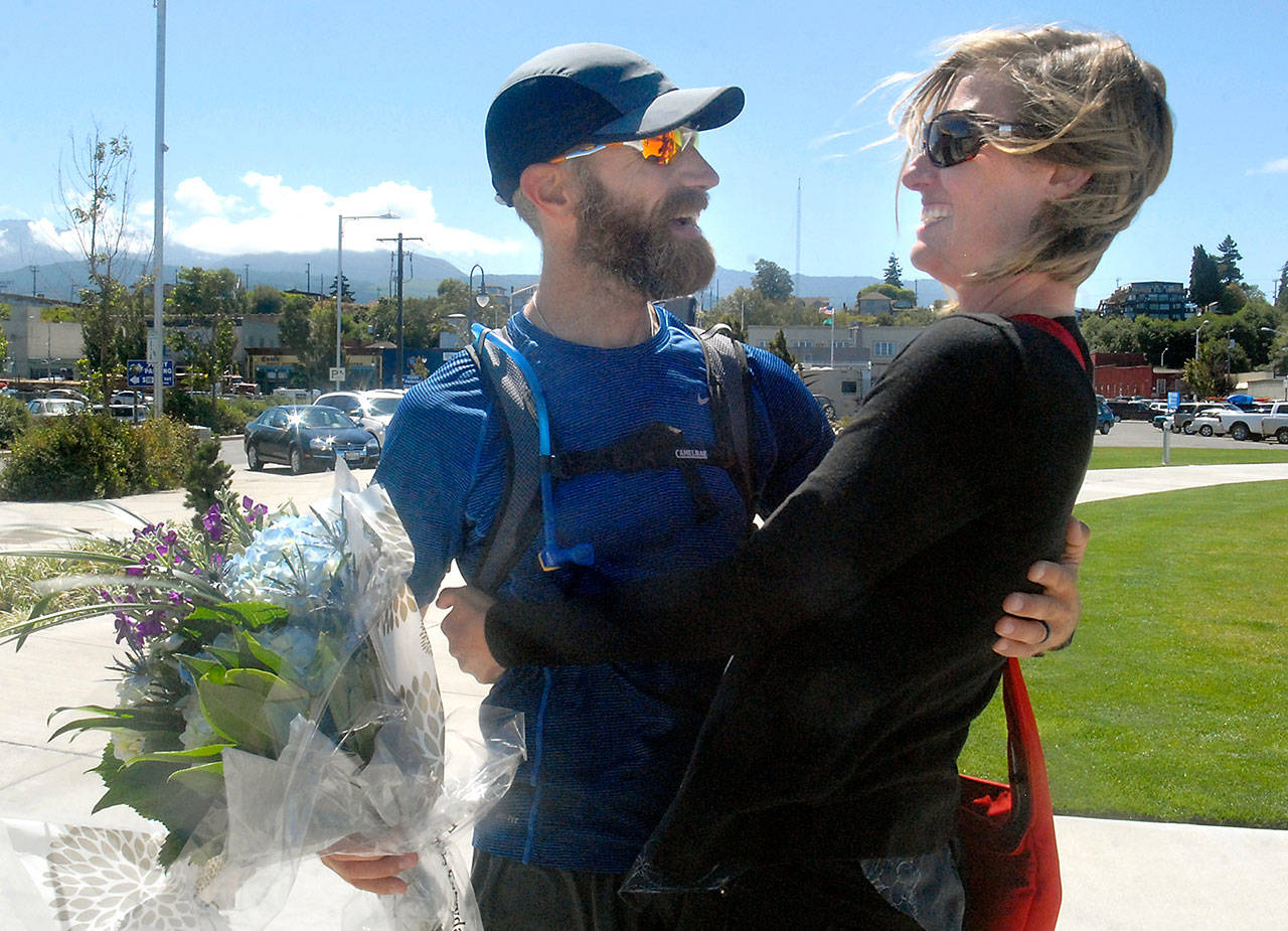 The Rev. Joe DeScala, director of Mended church in Port Angeles, is greeted by his wife, Makayla DeScala, at the completion of his 1,300-mile trek around Washington state to raise funds for orphans and widows. (Keith Thorpe/Peninsula Daily News)