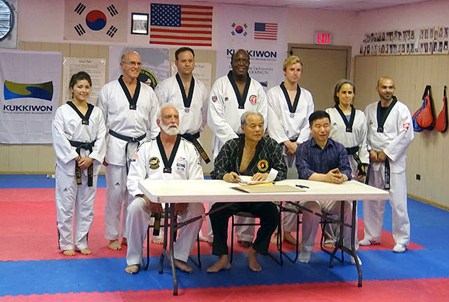 Grandmaster Robert Nicholls, seated at left, of White Crane Martial Arts in Port Angeles recently served on a blue-ribbon panel overseeing testing of potential Master taekwondo instructors. Fellow panelists were Kwon Duk Gun, president of the U.S. National Taekwondo Federation, center, and Olympic Gold Medalist Cho Jae Ho.