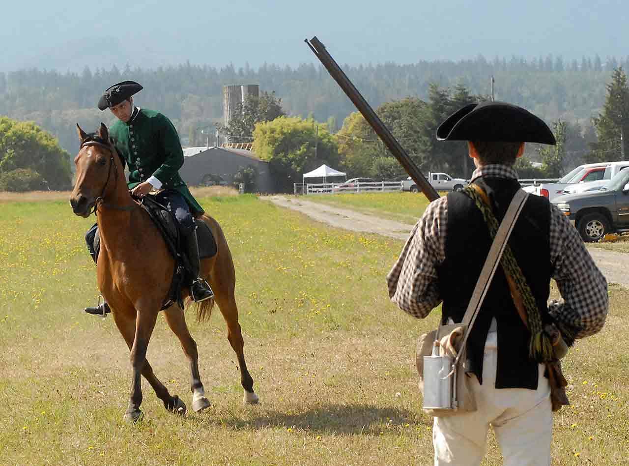 Paul Revere, portrayed by Colton Crouch of Carlsborg, rides the horse Reggie past militiaman Dave Rieve of Kent during a re-enactment of Revere’s famous ride as part of the Northwest Colonial Festival near Agnew last year. (Keith Thorpe/Peninsula Daily News)