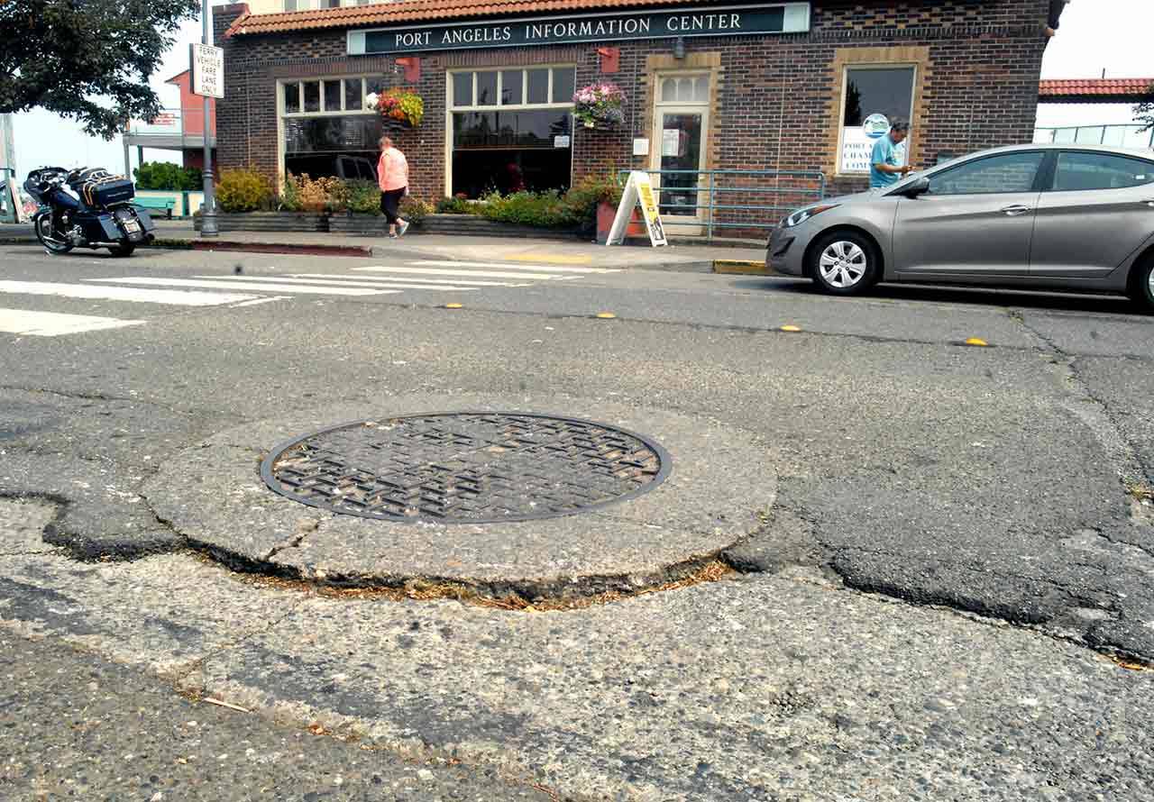 A damaged road surface in the 100 block of East Railroad Avenue greets visitors arriving in Port Angeles with a bumpy ride. (Keith Thorpe/Peninsula Daily News)