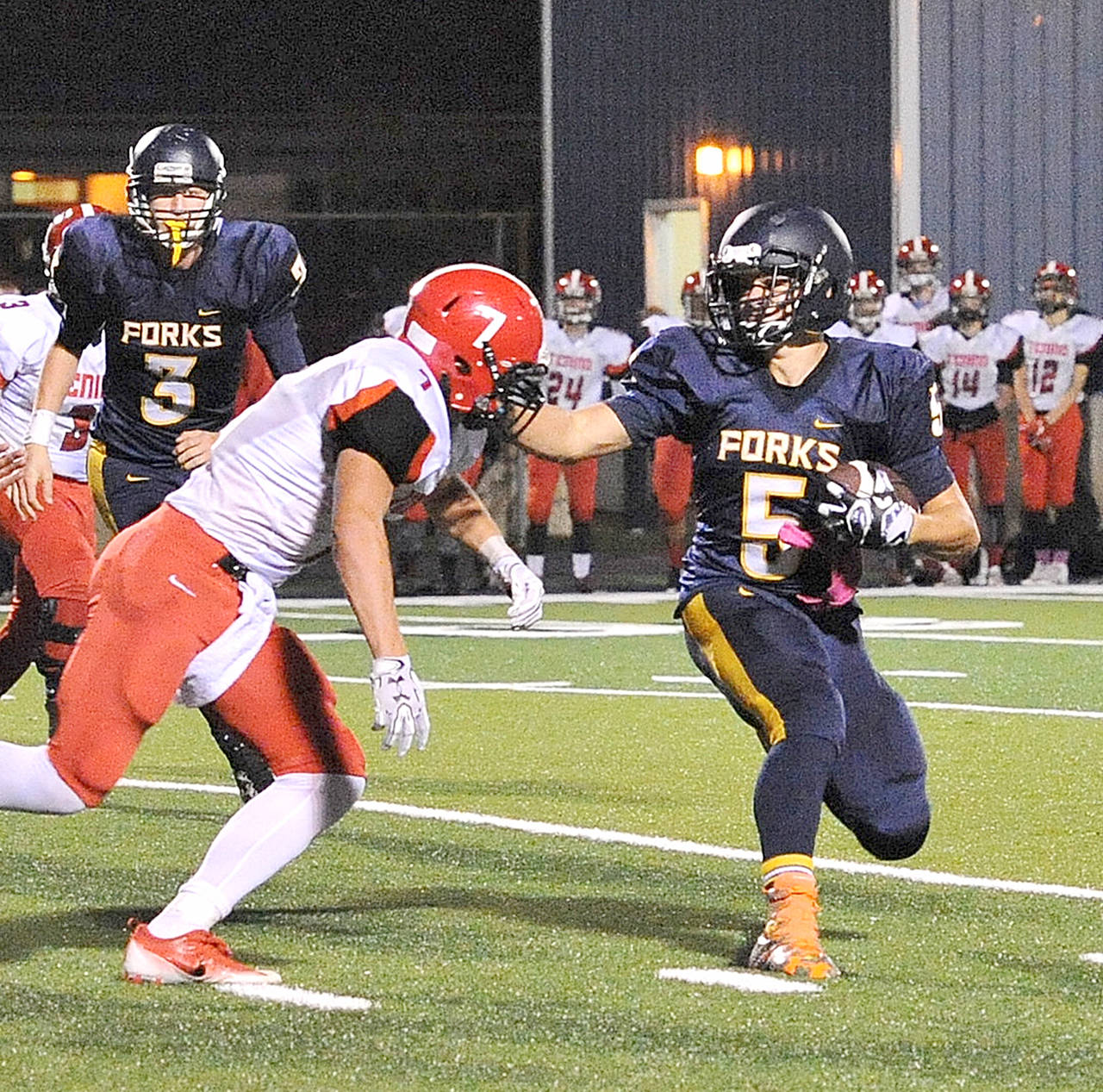 Forks’ Cole Baysinger, right, delivers a blow while reversing upfield in a win over Tenino last season. Baysinger, a senior, will see time all over the field this season for Forks.                                Lonnie Archibald/for Peninsula Daily News