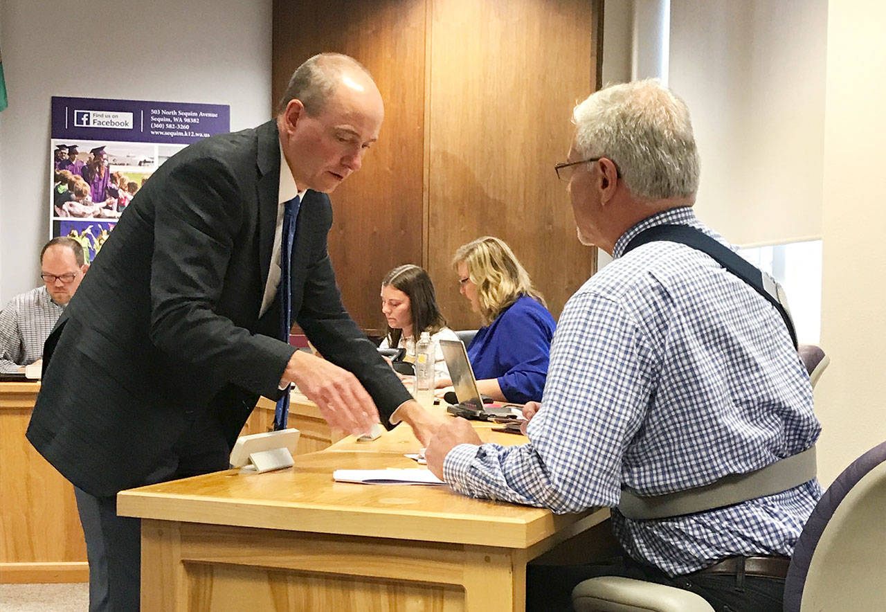 Left, Jim McNeill, bond attorney for the Sequim School District, goes over two resolutions with Sequim schools Superintendent Gary Neal at a school board meeting Monday. (Erin Hawkins/Olympic Peninsula News Group)