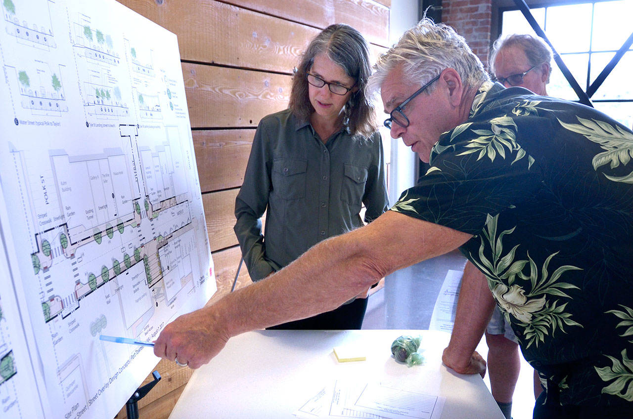 Paul Shutt, owner of one of the historic buildings along Port Townsend’s Water Street, talks with Laura Parsons, a civil engineer with the city of Port Townsend, at an open house Wednesday about plans to rehabilitate part of Water Street. (Cydney McFarland/Peninsula Daily News)