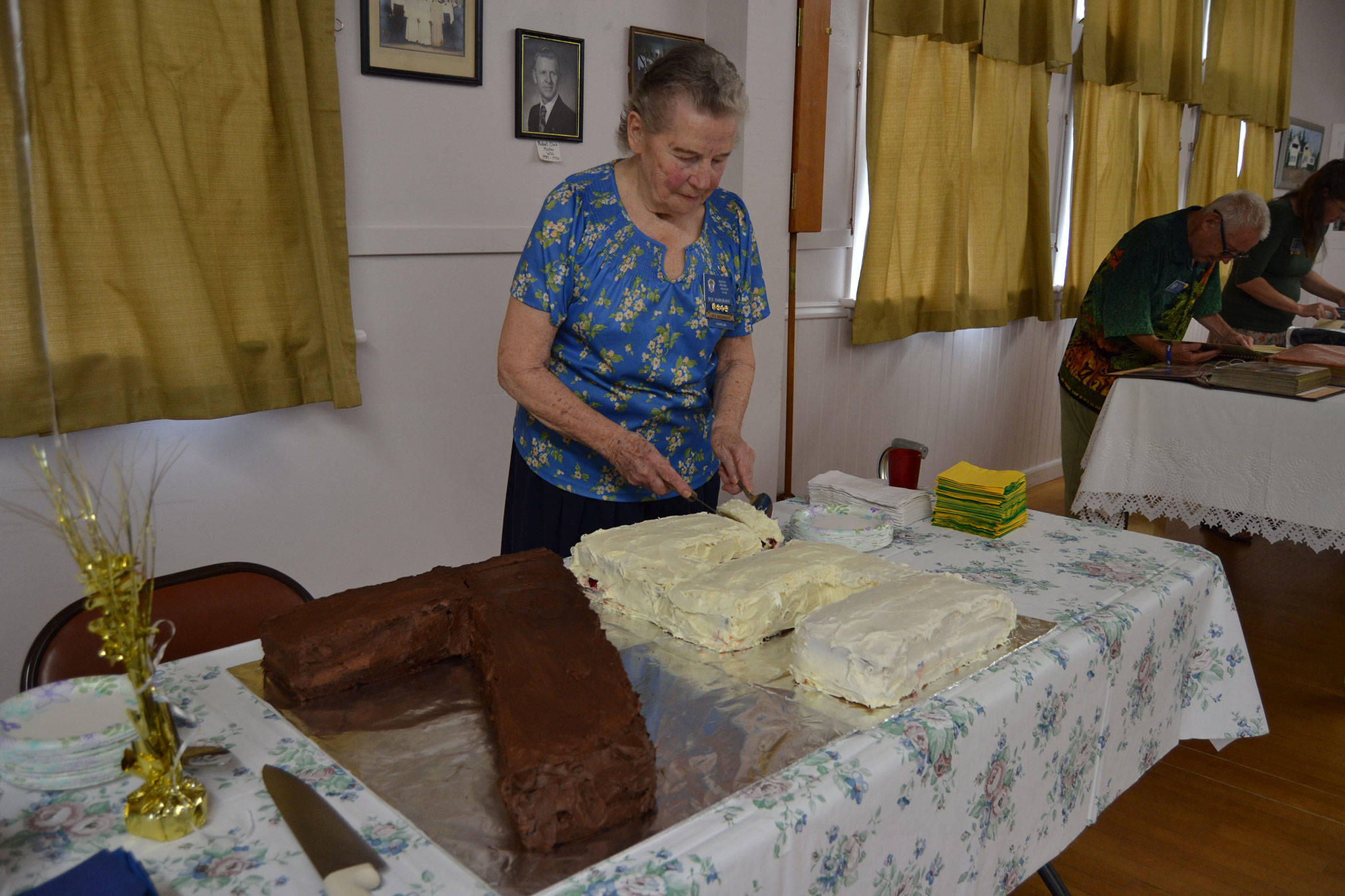 Sue Hargrave, organizer of the Sequim Prairie Grange’s 75th anniversary, cuts the cake she made commemorating the occasion on Aug. 9. Sequim Gazette photo by Matthew Nash