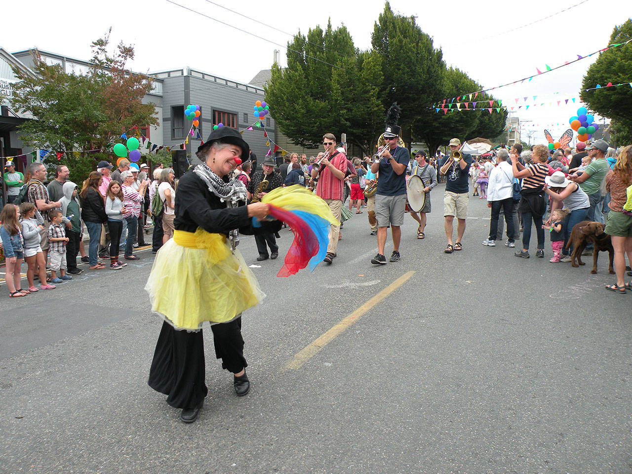 A clown at the Uptown Street Fair leads the band during the annual parade last year. (Mari Mullen)