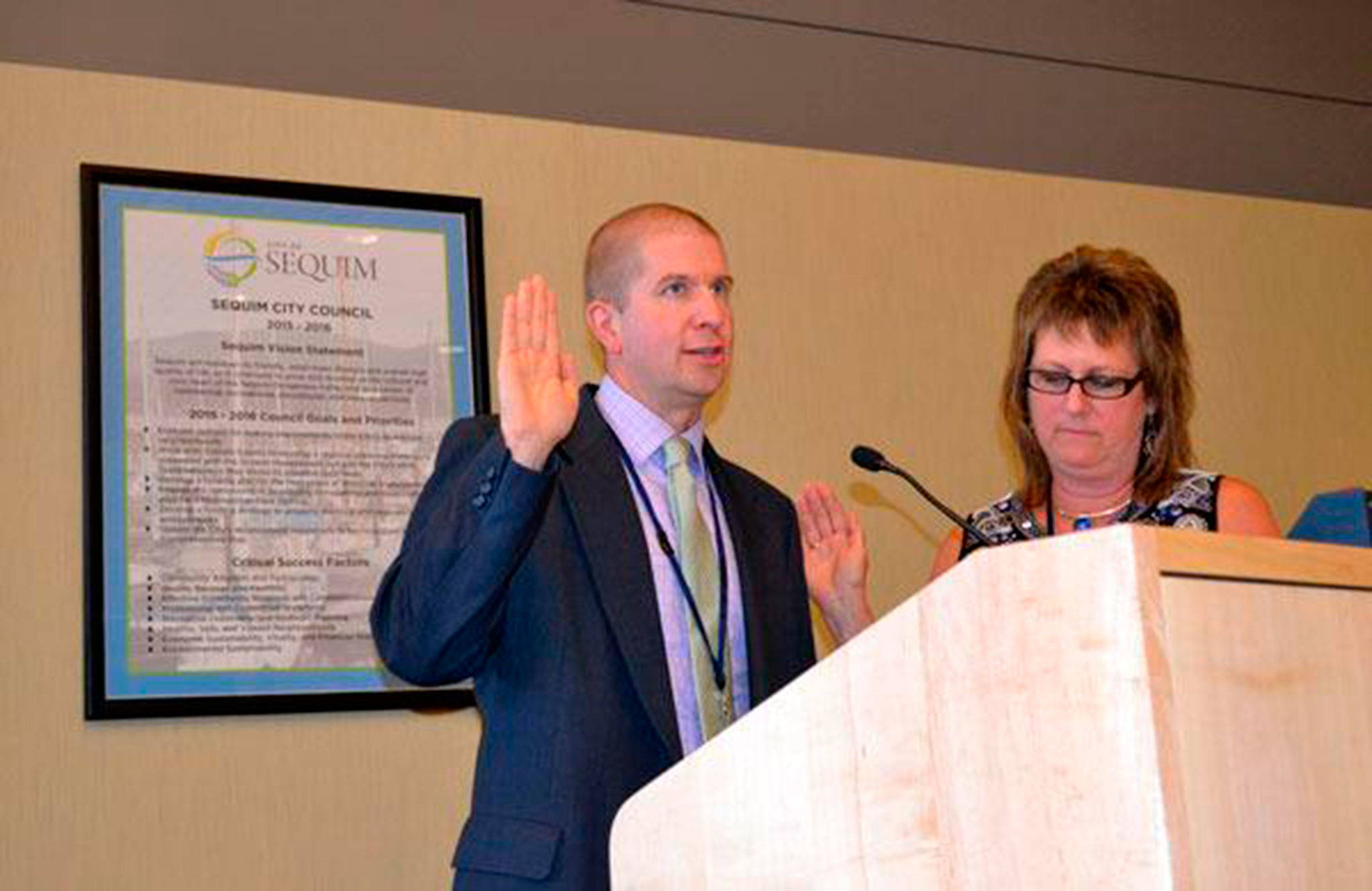 Matthew Nash/Olympic Peninsula News Group                                Sequim City Manager Charlie Bush, seen taking his oath of office Aug. 24, 2015, from Sequim City Clerk Karen Kuznek-Reese, recently received a positive review from the Sequim City Council and a raise.
